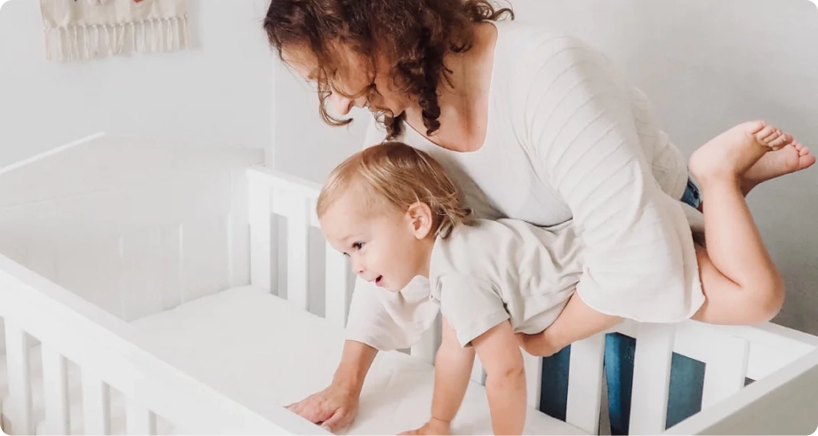 Mom with a kid in front of white bed
